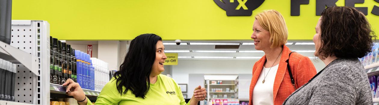 Freshco employee talking to customers in store aisle