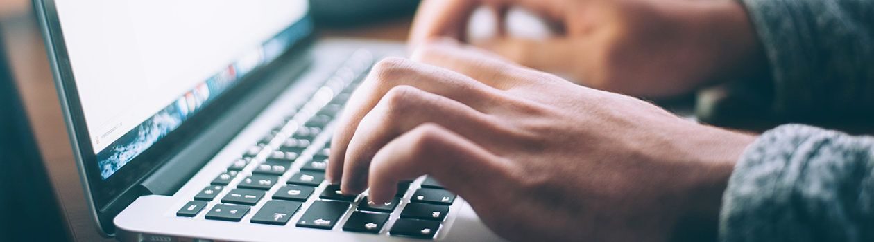 Person typing on laptop keyboard